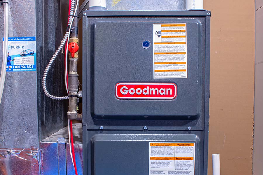 Goodman gas furnace installed in a basement with copper gas line and shutoff valve