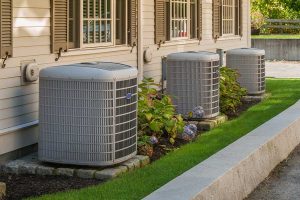 Three condensers along the side of a home